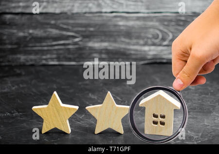 Zwei Holz- Sterne und ein Haus. Zwei Sterne Hotel oder Restaurant. Überprüfung der Kritiker. Qualität der Dienstleistung und Service. Bewertung der Häuser und Privat Stockfoto