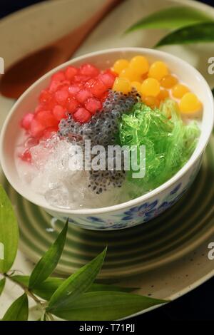 Eisige asiatischer Nachtisch von Thai Red Ruby Perlen, bubble Gelee, agar Nudeln, Basilikum Samen und crushed Ice in Kokosmilch Suppe. Stockfoto