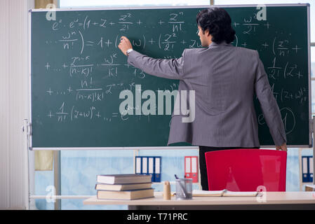 Junge schöne Mathematik Lehrer im Klassenzimmer Stockfoto