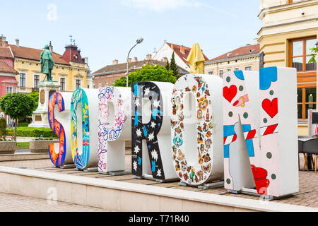 Das Wort Sopron in großen 3D Buchstaben mit abstrakten Gemälden und die Statue von Széchenyi István geschrieben Stockfoto