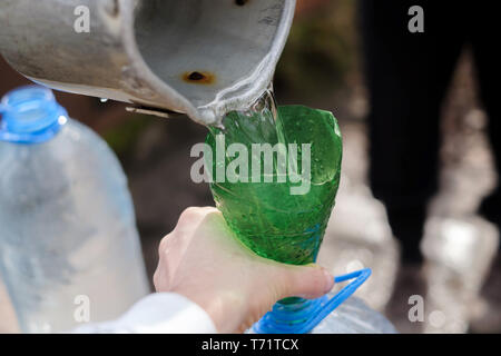 Mann mit Schaufel und Trichter Zeichnung Wasser aus gut Stockfoto