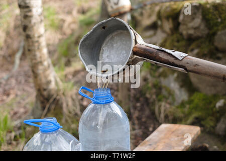 Kaukasische Mann mit Schaufel Zeichnung Wasser aus dem alten Brunnen Stockfoto