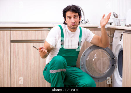 Junge Unternehmer die Reparatur Waschmaschine in der Küche Stockfoto