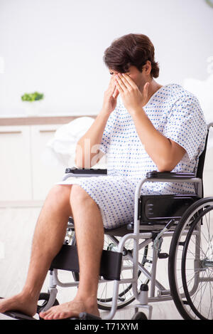 Jungen gutaussehenden Mann im Rollstuhl im Krankenhaus Stockfoto
