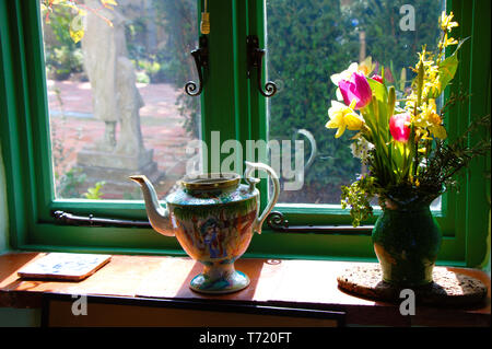 Grünes Fenster dekoriert mit Fensterbank. Antiken englischen Stil. Blumen in einer Vase und einem Kaffee Kanne auf einer Fensterbank. Stockfoto