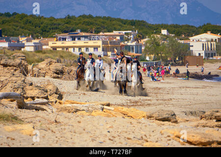 Sohn Sera De Marina - Mallorca - Spanien - April 2019: Lokale Reitführer führt eine Gruppe von Touristen Galopp am Strand Stockfoto