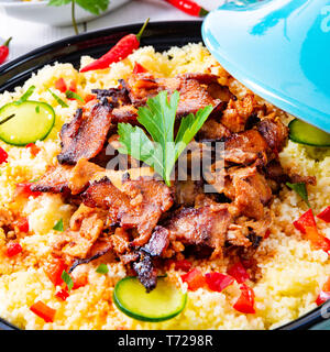 Tajin mit Couscous, Gemüse und Fleisch auf weißem Hintergrund Stockfoto