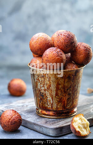 Hüttenkäse Donuts in einem alten Eimer. Stockfoto