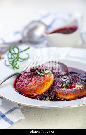 Quark Pfannkuchen mit kirschsauce mit Rosmarin. Stockfoto