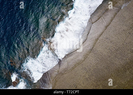 Wellen aus dem Pazifischen Ozean stürzt gegen die Wellenbrecher in Korotogo Strand. Stockfoto