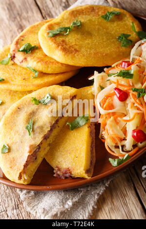 Traditionelle Lateinamerikanische pupusas serviert mit curtido Closeup auf einem Teller auf den Tisch. Vertikale Stockfoto