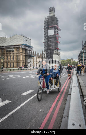 Eine Rikscha Fahrer und Beifahrer auf die Westminster Bridge, London, UK Stockfoto