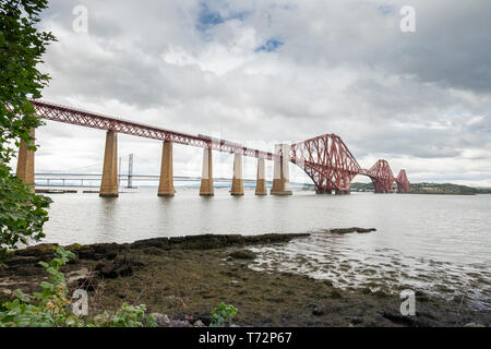 Zug auf die Forth Eisenbahnbrücke über den Firth-of-Forth, in der Nähe von South Queensferry Edinburgh, Lothian, Schottland. Die Brücken sind im Hintergrund Stockfoto