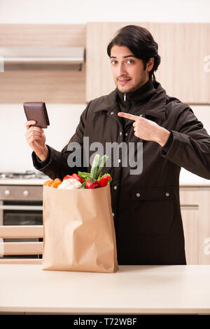 Junger stattlicher Mann mit Gemüse in der Küche Stockfoto