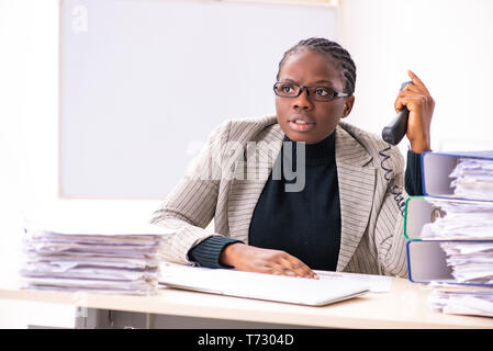 Schwarze weibliche Mitarbeiter mit übermäßiger Arbeit unzufrieden Stockfoto