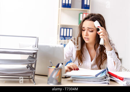 Junge weibliche Mitarbeiter mit übermäßiger Arbeit unzufrieden Stockfoto