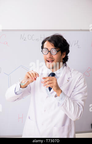 Junge lustig Chemiker vor white board Stockfoto