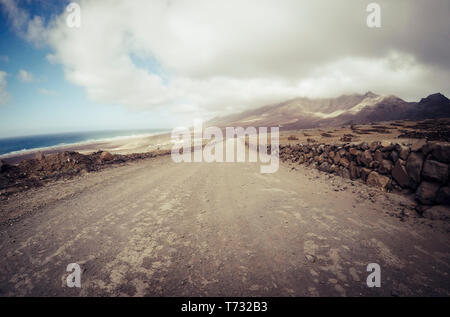 Lange off road Gelände weg Straße gesehen vom Boden aus mit Bergen und Küste auf das Meer - Reisen und Abenteuer Konzept für alternative vacatio Stockfoto