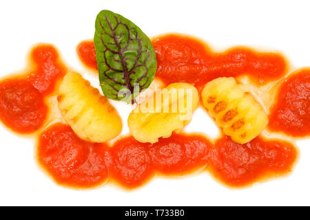 Gebratene Gnocchi mit Tomatensauce und rote Ader Dock auf Weiß Stockfoto