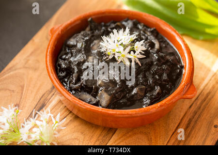 Eine Schale mit frisch Tintenfisch zubereitet, Sepia officinalis, von einem Tintenfisch, die in den englischen Kanal gefangen wurde. Es hat geschmort in Ihrer eigenen Tinte. Stockfoto