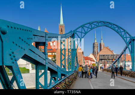 Breslau, Niederschlesien, Polen. Dominsel Brücke, die zum Ostrow Tumski Bezirk. Glockentürme der Stiftskirche Heilig Kreuz. Stockfoto