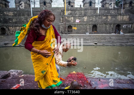 Leben nach dem Erdbeben. Älterer Mann und Frau anbeten am Pashupatinath Tempel. Ein Erdbeben der Stärke 7.8 struck Nepal um 11:56 Uhr, am 25. Apri Stockfoto