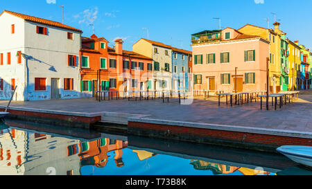 Wunderschöne Aussicht auf die Kanäle von Burano mit Booten und schöne, farbenfrohe Gebäude. Burano Dorf ist bekannt für seine bunten Häuser. Venedig, Italien. Stockfoto