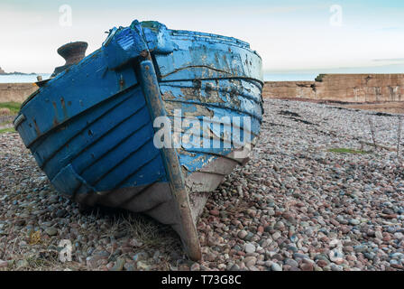 Verwittert und Distressed blau kleine Küstenfischerei Klinker gebaut Fischerboot Strände auf einem Kiesstrand im Nordosten von Schottland Stockfoto