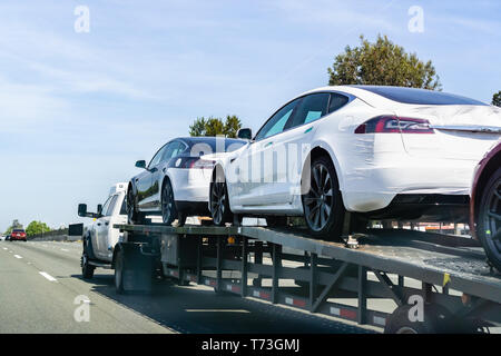 April 26, 2019 Redwood City/CA/USA - Autotransporter trägt Tesla Modell 3 neue Fahrzeuge entlang einer Straße in San Francisco Bay Area, Rückansicht des Th Stockfoto