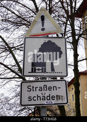 Straßenschild vor den Gebäuden. Die Aufmerksamkeit der Verkehrsteilnehmer wegen der Straße beschädigt werden. Stockfoto