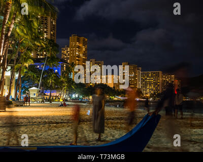 Menschen zu Fuß auf den Strand bei Sonnenuntergang in Waikiki, Waikiki, Oahu, Hawaii, Vereinigte Staaten von Amerika Stockfoto