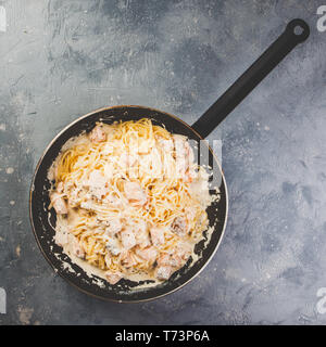 Italienische Pasta Linguine mit Lachs in Sahnesoße in der Pfanne. Ansicht von oben. Stockfoto