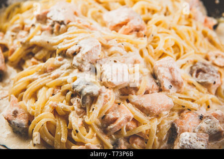 Italienische Pasta Linguine mit Lachs in Sahnesoße in der Pfanne Stockfoto