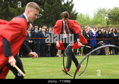 Schülerinnen und Schüler nehmen an der jährlichen König Ely Hoop Trundle im Osten Rasen an Ely Cathedral, die Gründung der Schule durch König Heinrich VIII., 1541. Der Kurs ist ein 75 Yard dash an einem Pfosten und wieder zurück, während Bowling die Hoop mit einem Holzstab. Stockfoto