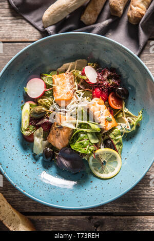 Frisches Gemüse Salat mit gebratenem Lachs Olivenöl und Baguette. Stockfoto