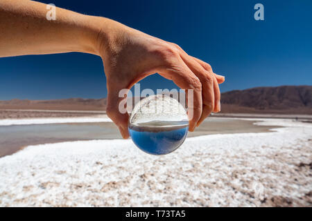 Hand mit Glas Kugel an Salzseen in Atacama Stockfoto