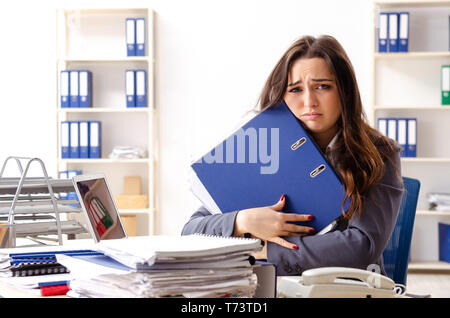 Junge weibliche Mitarbeiter mit übermäßiger Arbeit unzufrieden Stockfoto