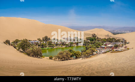 Oase von Huacachina in der Nähe von Ica-Stadt in Peru. See und Bäume in den Dünen Stockfoto
