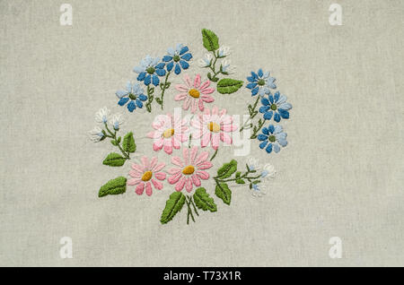 Bestickte Bouquet von rosa, blau und weiße Blumen und grüne Blätter auf dem Hintergrund aus Baumwolle Stockfoto