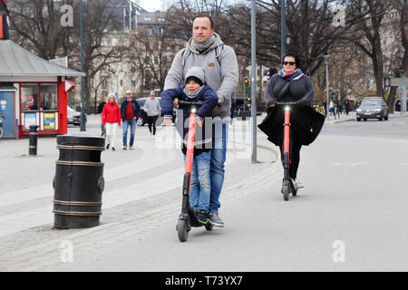 Stockholm, Schweden - 22 April, 2019: eine Familie nutzt Vermietung Elektroroller für Transport am Nybroplan Bereich. Stockfoto