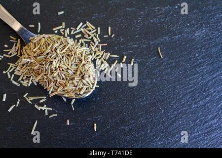 Löffel aus Holz mit getrockneten Rosmarin. Ansicht von oben und Platz kopieren Stockfoto