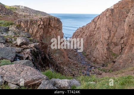 Fluss und Meer entlang der felsigen Küste mit schwerem Wasser fließen in einem Waldgebiet, Motion Fluss Stockfoto