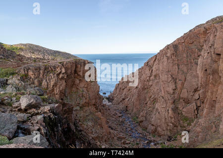 Fluss und Meer entlang der felsigen Küste mit schwerem Wasser fließen in einem Waldgebiet, Motion Fluss Stockfoto