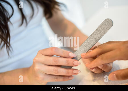 Frau in einem Nails Salon empfangen einer Maniküre mit Nagelfeile Stockfoto