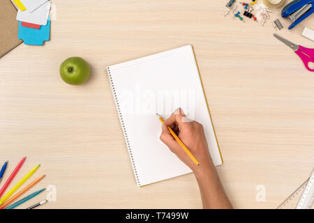 Holz- Schreibtisch Arbeitsplatz Draufsicht person Hausaufgaben im Notebook close-up Stockfoto