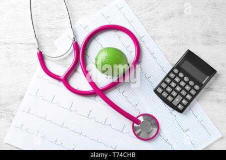 Stethoskop mit Taschenrechner und Cardiograms auf Holz- Hintergrund. Health Care Konzept Stockfoto