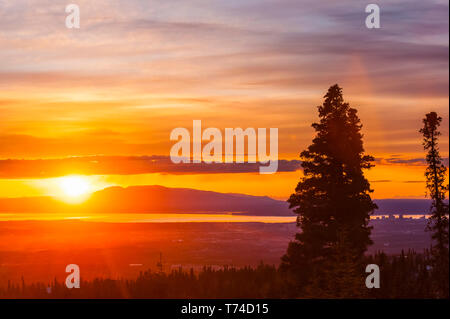 Die untergehende Sonne über Alaskas Mount Susitna, lokal bekannt als "The Sleeping Lady", mit dem Cook Inlet und der Stadt Anchorage im Vordergrund ... Stockfoto