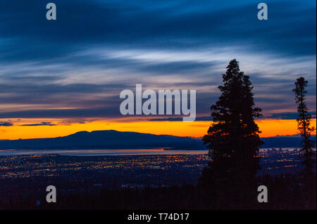 Die untergehende Sonne über Alaskas Mount Susitna, lokal bekannt als "The Sleeping Lady", mit dem Cook Inlet und der Stadt Anchorage im Vordergrund ... Stockfoto