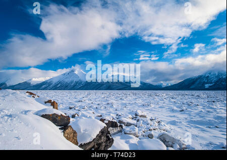 Eine Landschaft von Wolken über dem gefrorenen Cook Inlet im Süden - zentrales Alaska mit der Chugach Mountains im Hintergrund an einem Wintertag Stockfoto