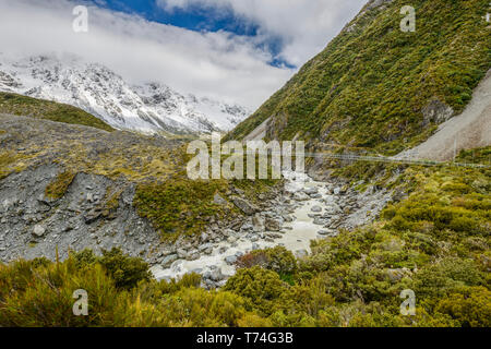 Snowy Mountains und Hängebrücke entlang der Hooker Valley Track, Mount Cook National Park; South Island, Neuseeland Stockfoto